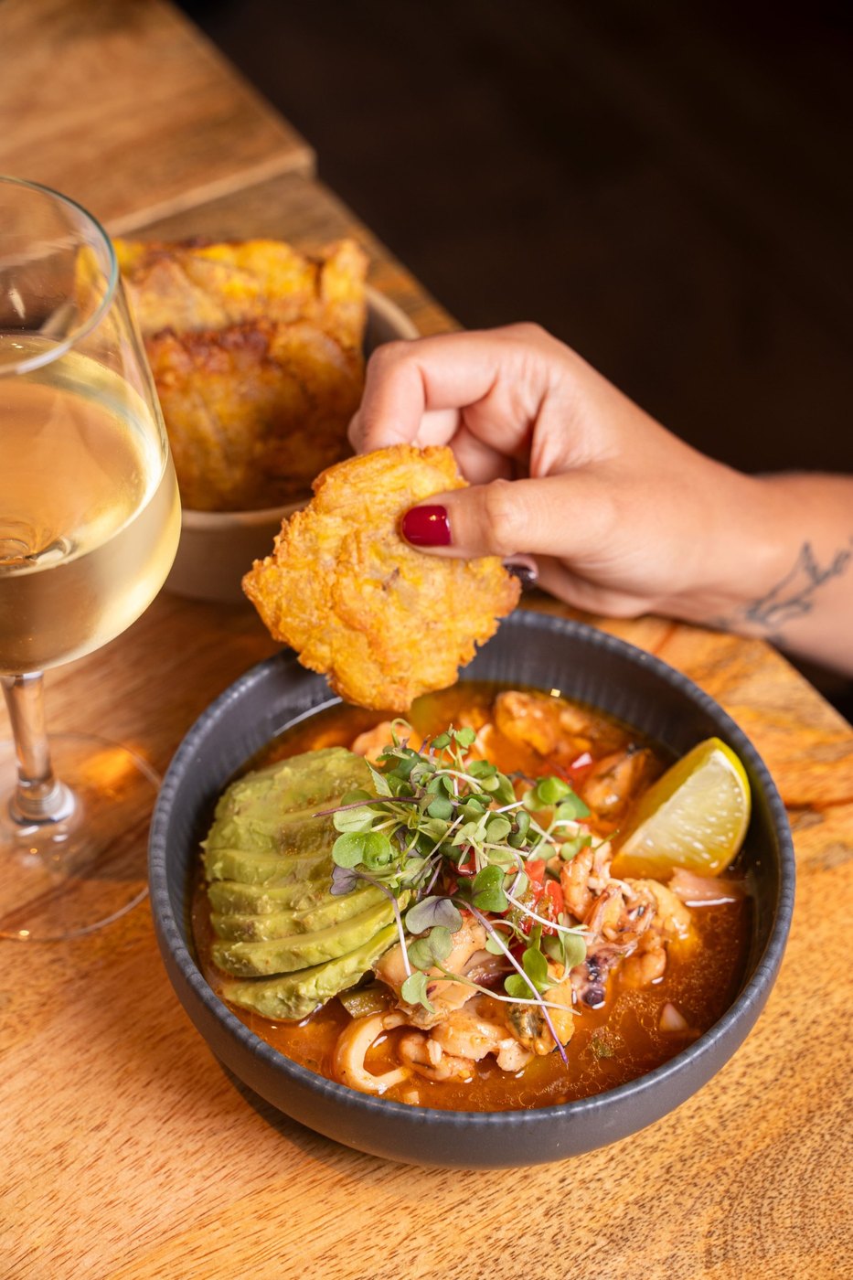 Seafood soup with avocado and a patacón dipped in, at La Churuata