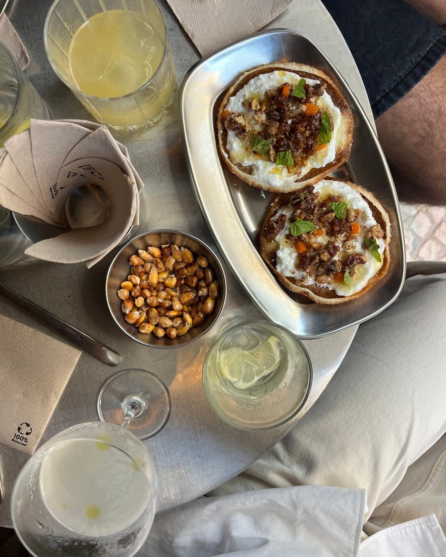 Won tons, toasted corn and drinks on a metal table at a Lisbon gastro bar