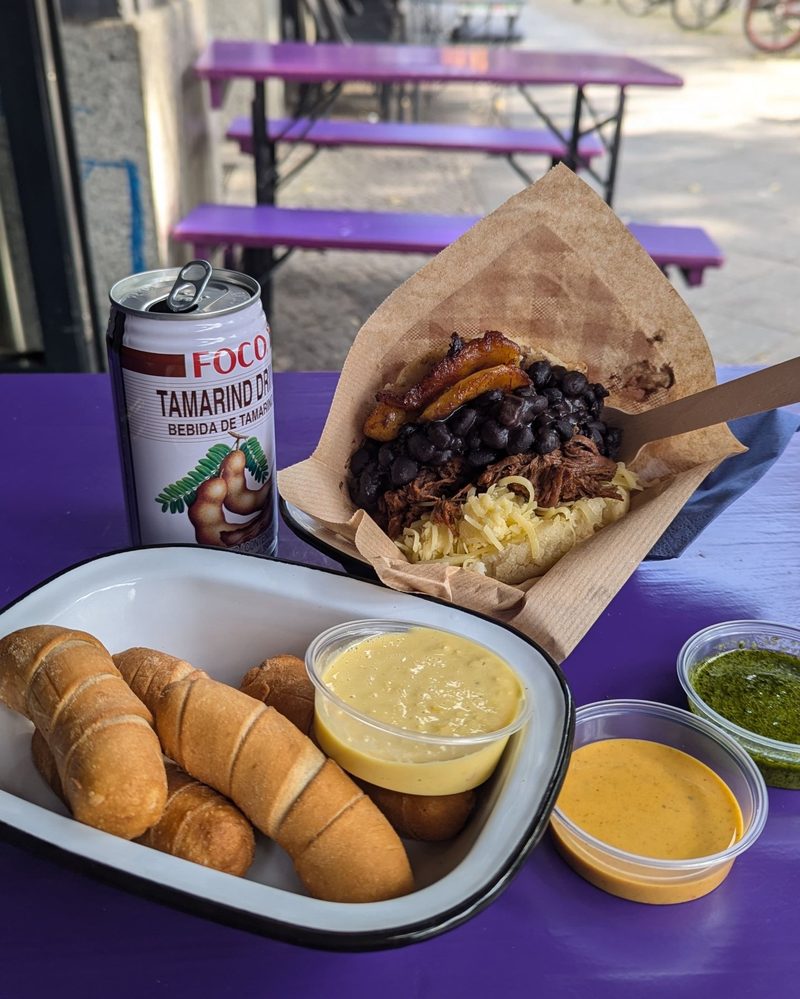 Arepa and tequeños on a purple table